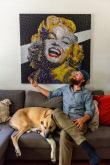 Jeffrey Meszaros with his dog, Gus, and a bottle cap mosaic of Marilyn Monroe